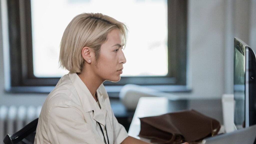 Data Entry Operator Jobs in Dubai 2026 – Full Guide for Freshers & Experienced Candidates Office employee working at a computer with documents on the desk beside her